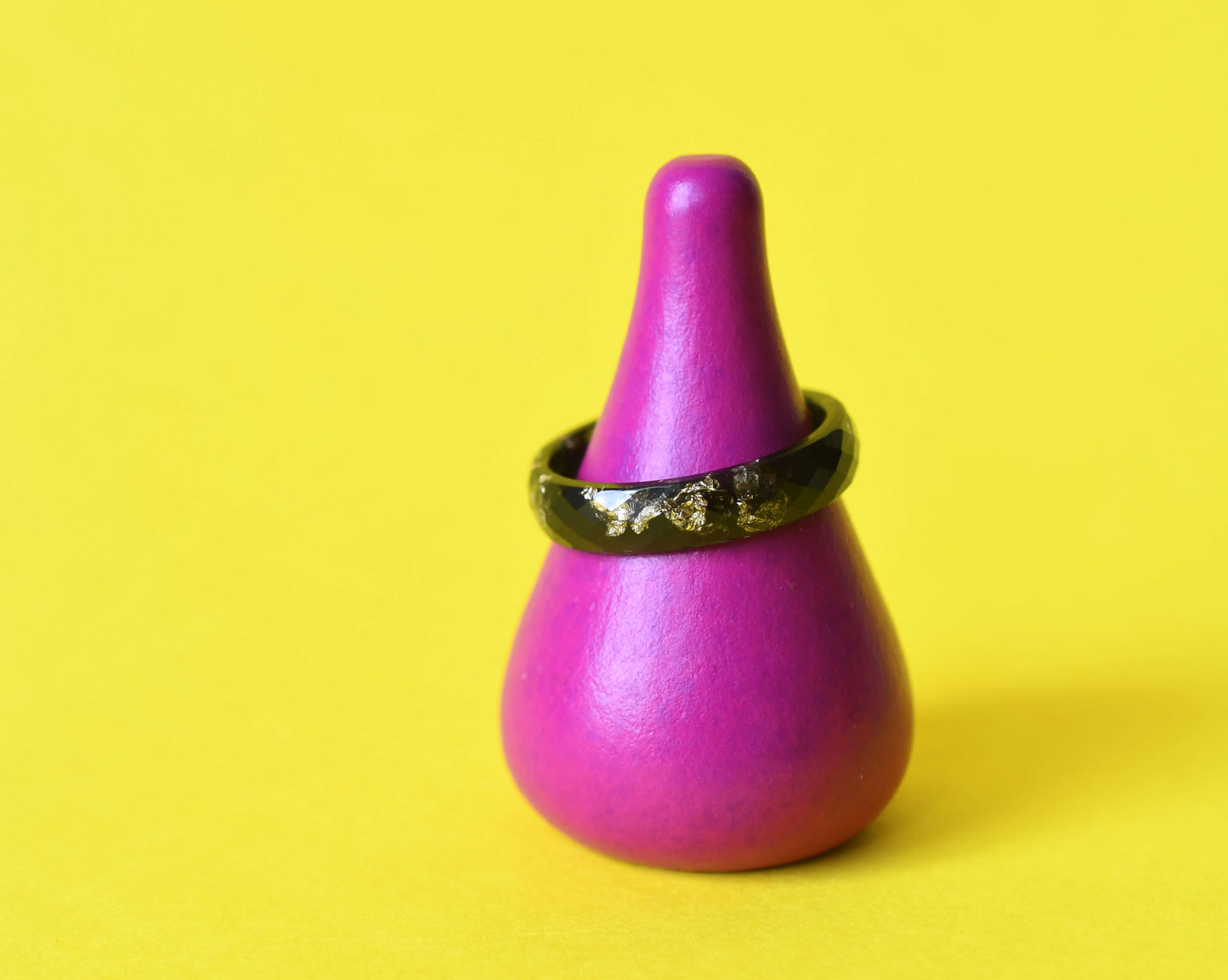 Close-up of gold leaf in faceted black resin ring, Flatlay of handmade black resin ring with gold flakes