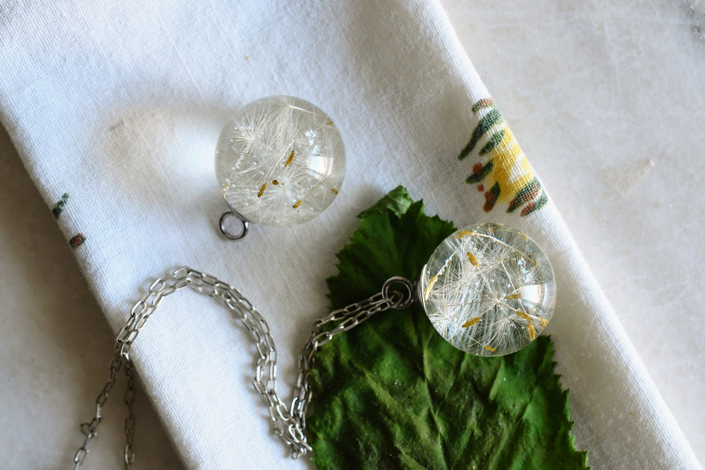 Clear resin jewelry with preserved dandelion