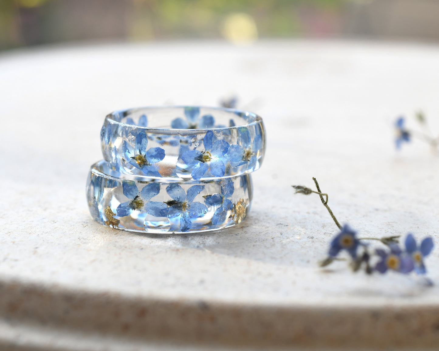 Transparent resin ring featuring real flowers and metallic gold inclusions