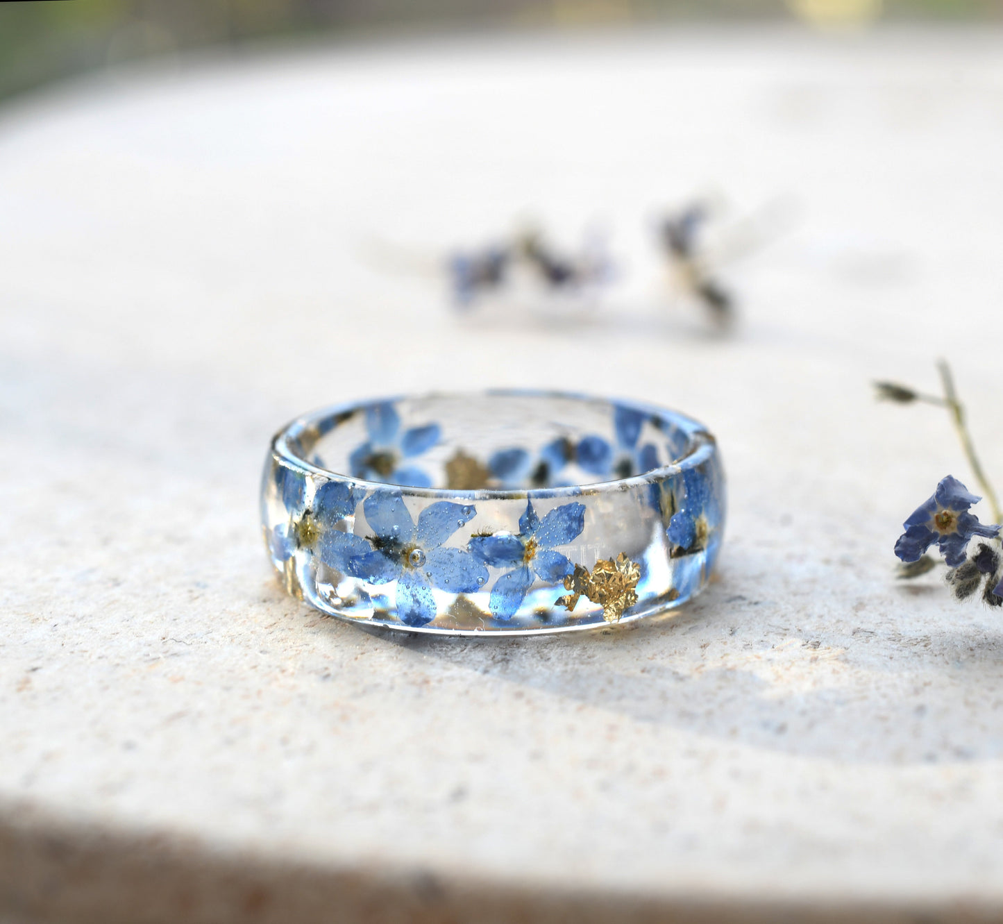 Unique floral resin ring with gold flakes and forget-me-nots on a glossy wide band
