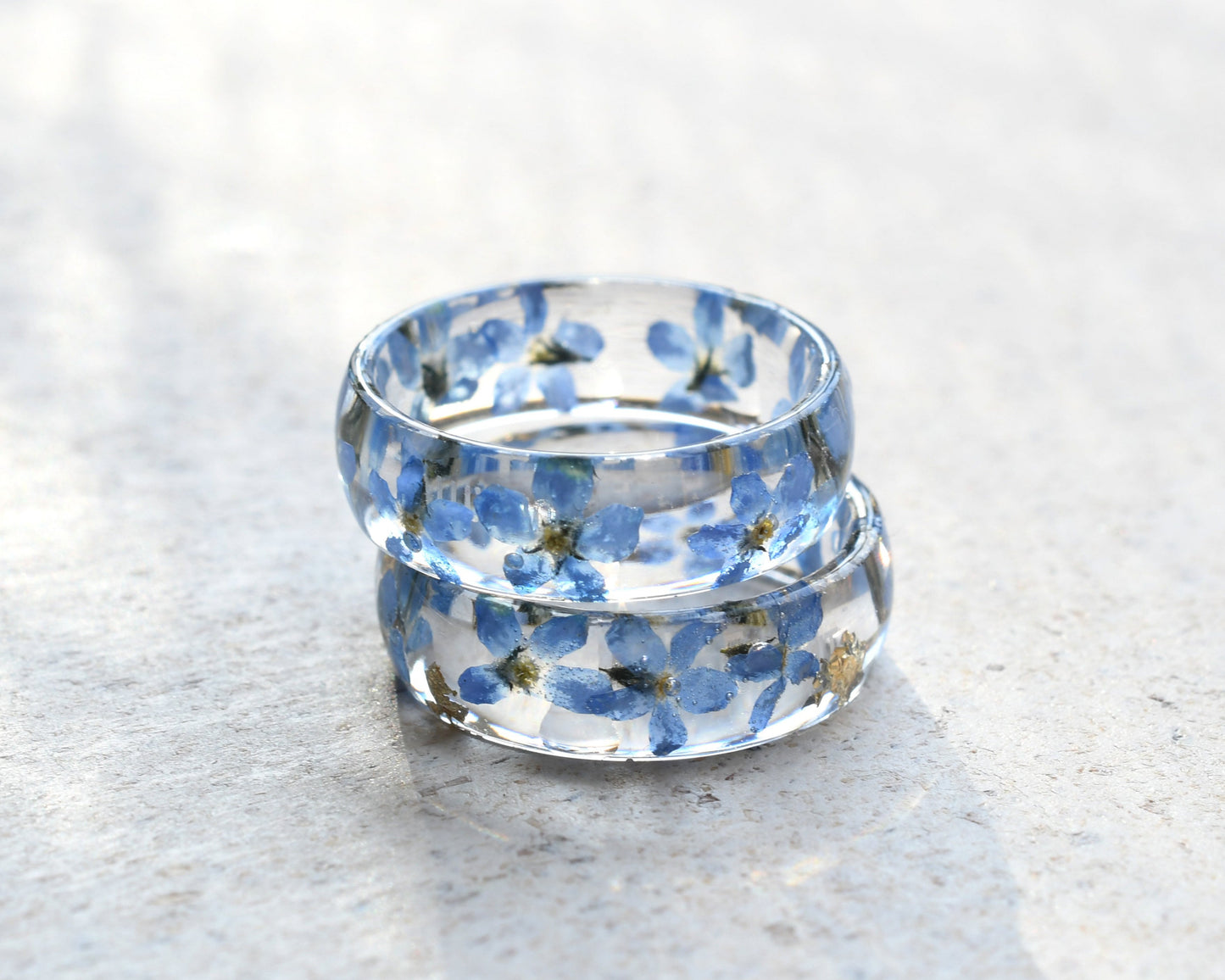 Clear ring with blue floral design on a light gray surface