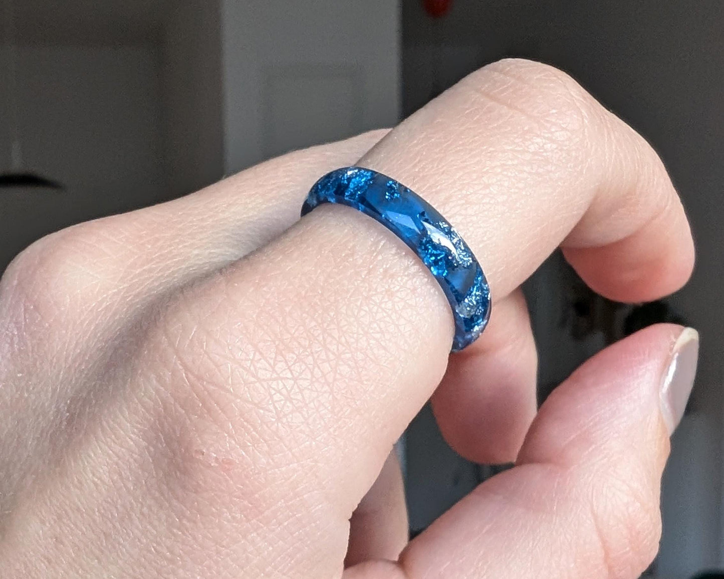 Blue and silver resin ring worn on hand