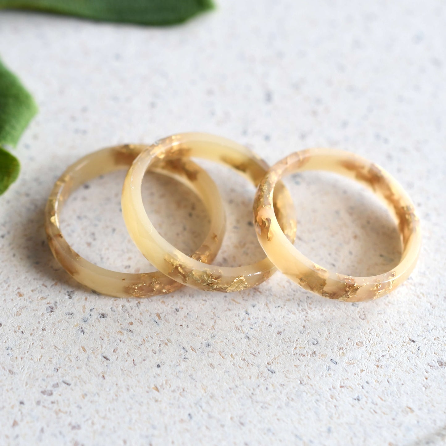 lose-up of gold flakes in nude resin band