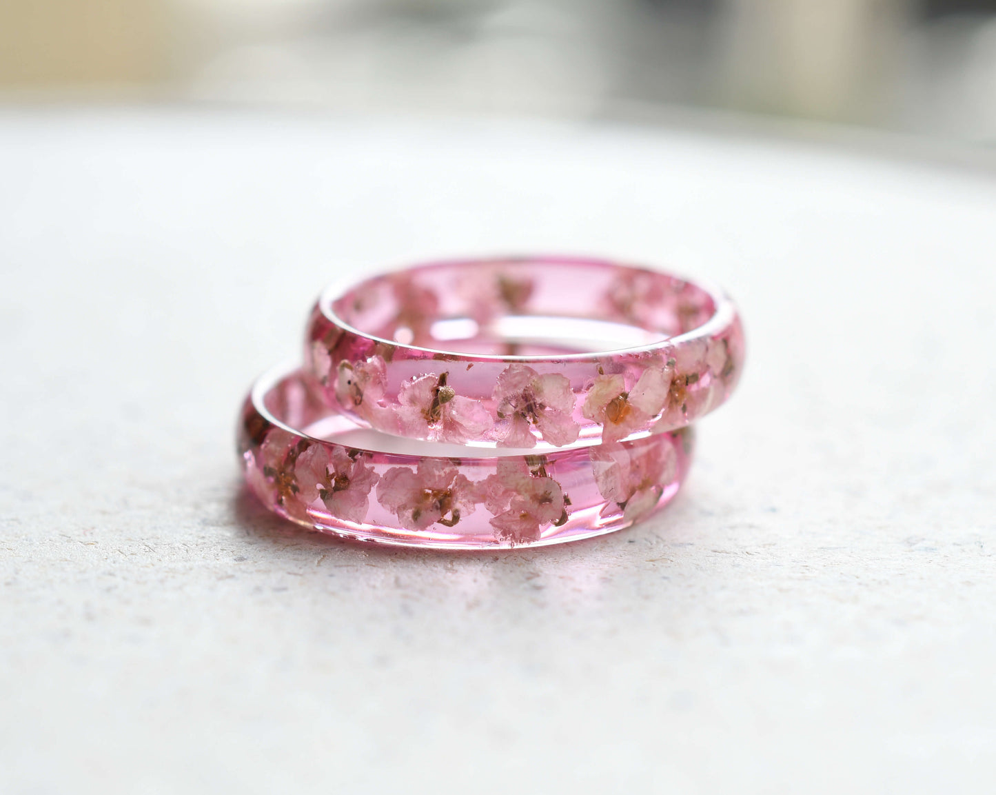 Flatlay of handmade pink ring with white flower