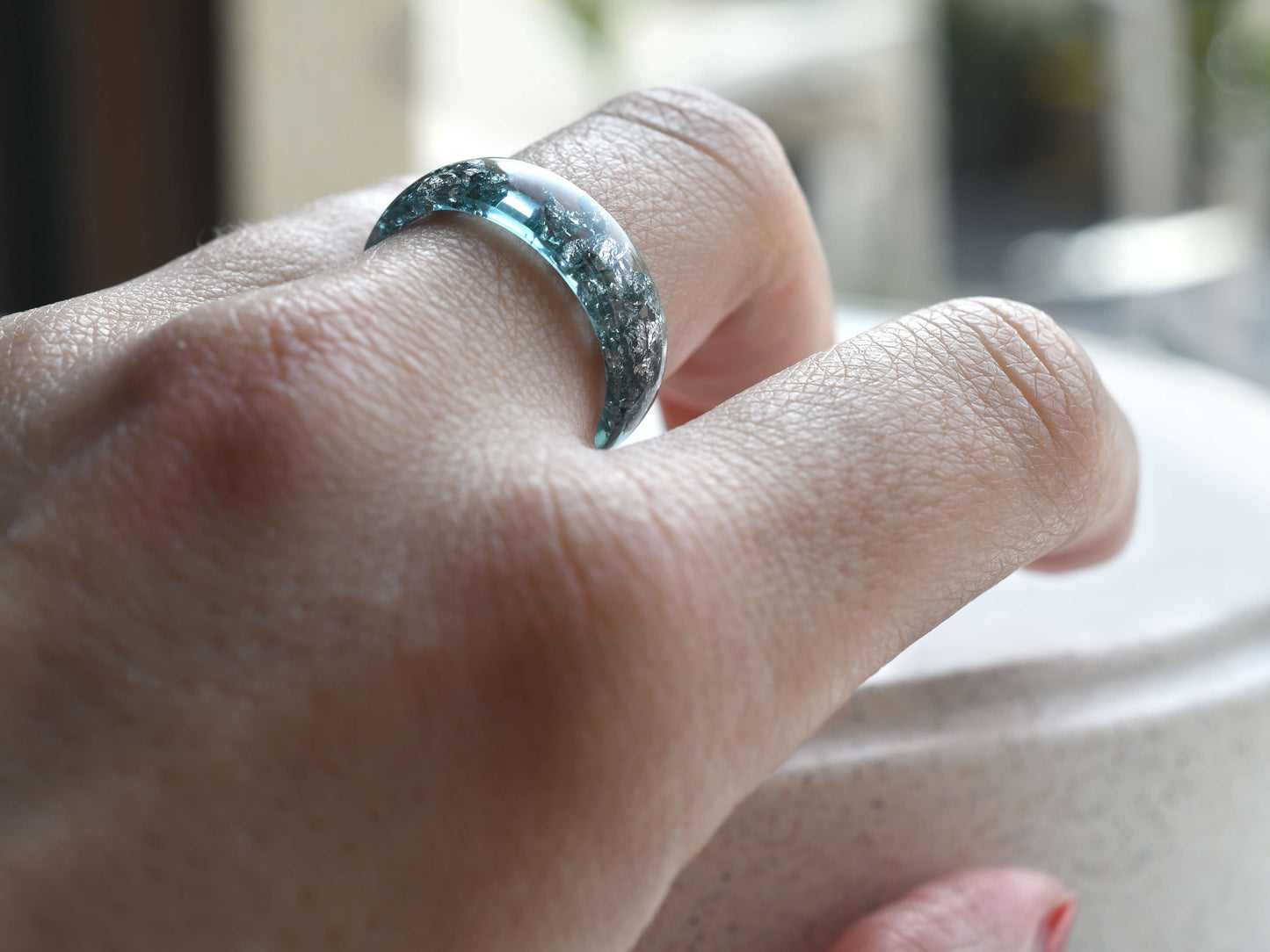 Aquamarine and silver resin ring worn on hand