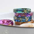 Chromatic resin ring — translucent color and metallic shimmer.