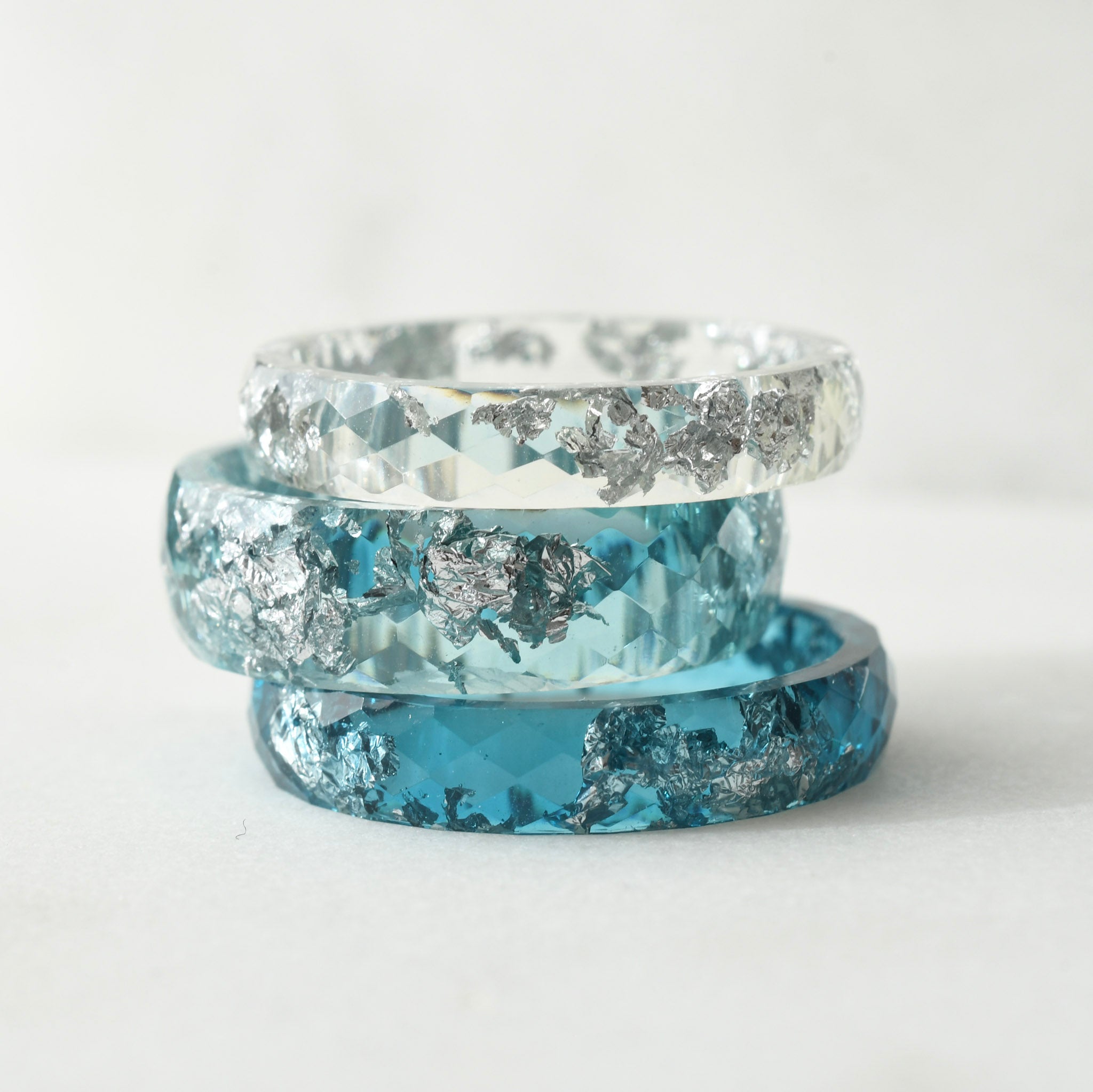 Three blue and silver rings stacked on a white background