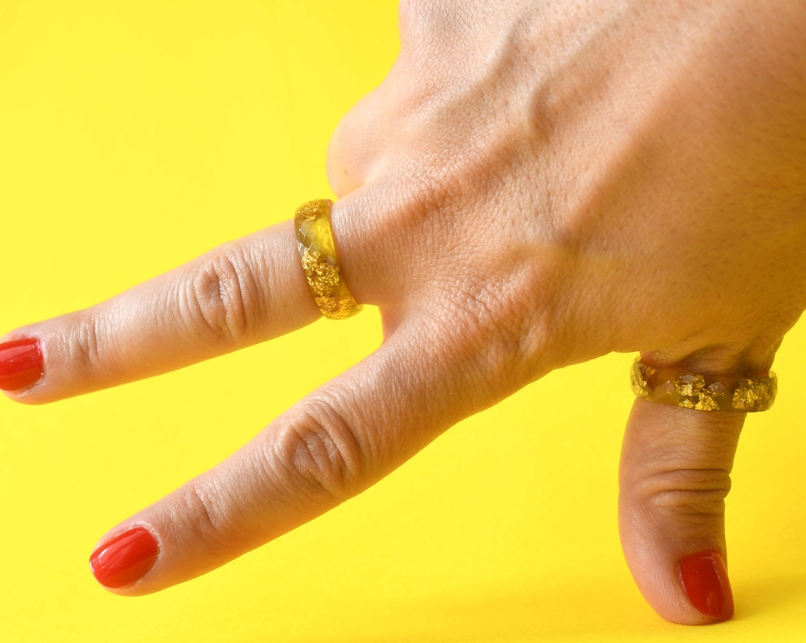 Close-up of faceted neon yellow resin ring with shimmering gold accents