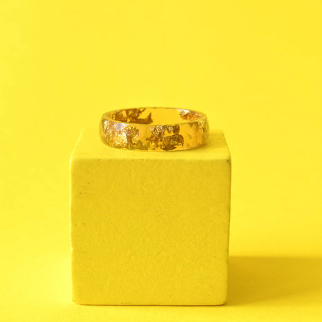 Flatlay of Solar Signal Ring showing gold leaf in vibrant yellow resin