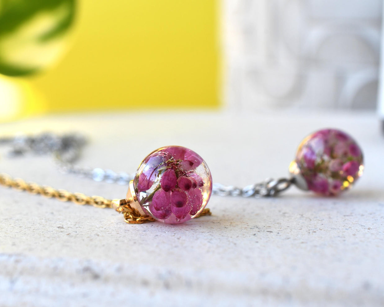Side view of spherical pendant with clear resin and floral inclusion