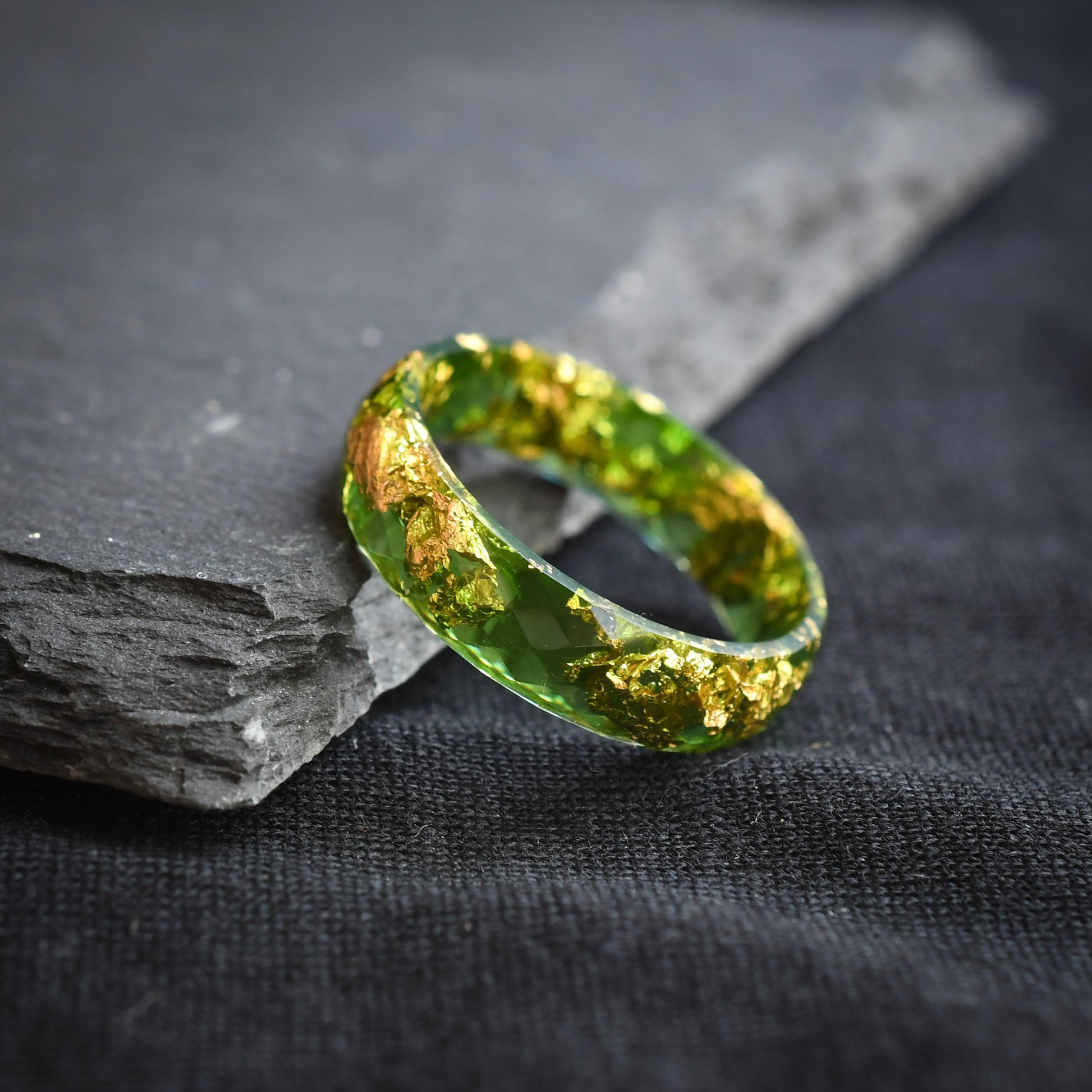 close up alternative men’s wedding ring green gold leaf