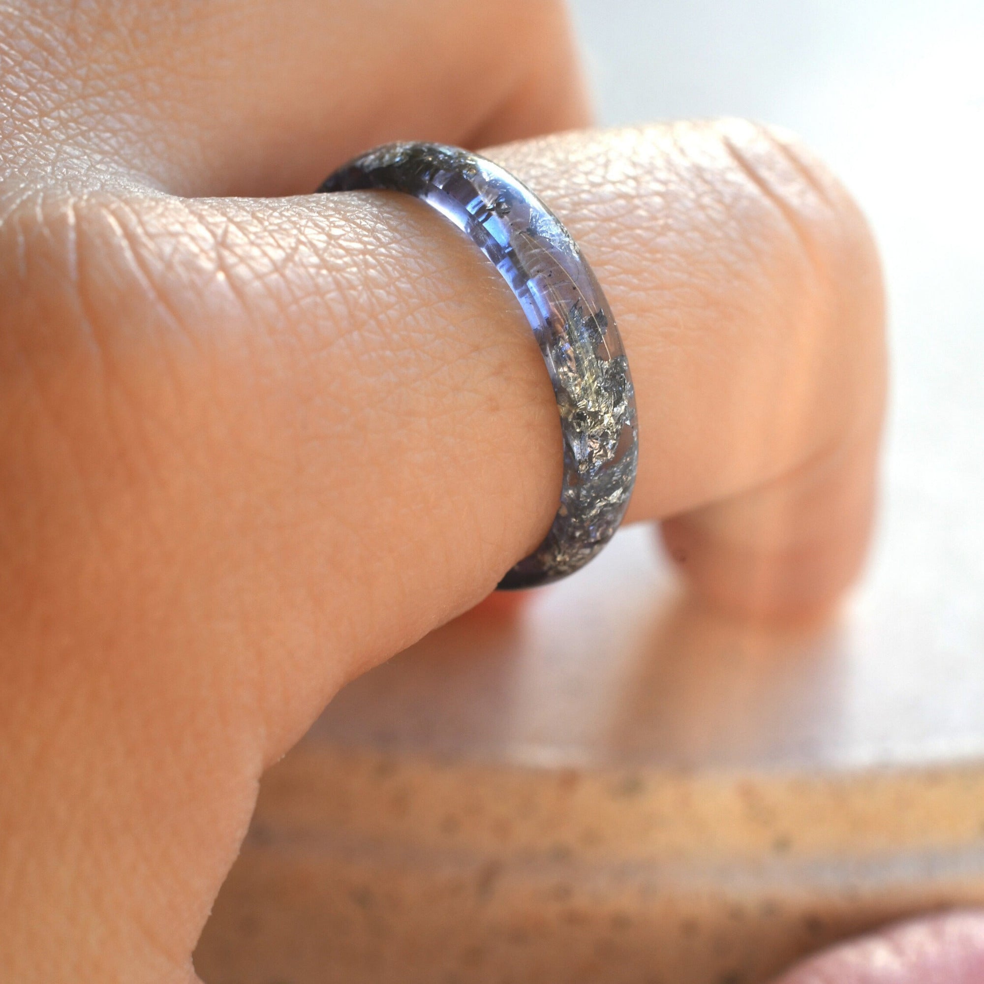 Close-up of amethyst colored resin ring showing shimmering silver leaf texture