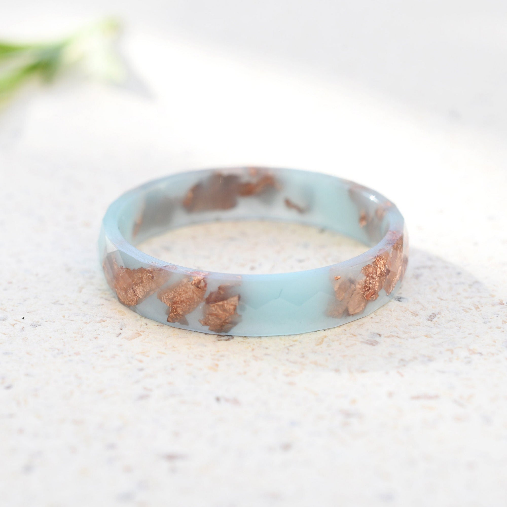 Close-up of rose gold flakes inside baby blue resin handmade ring