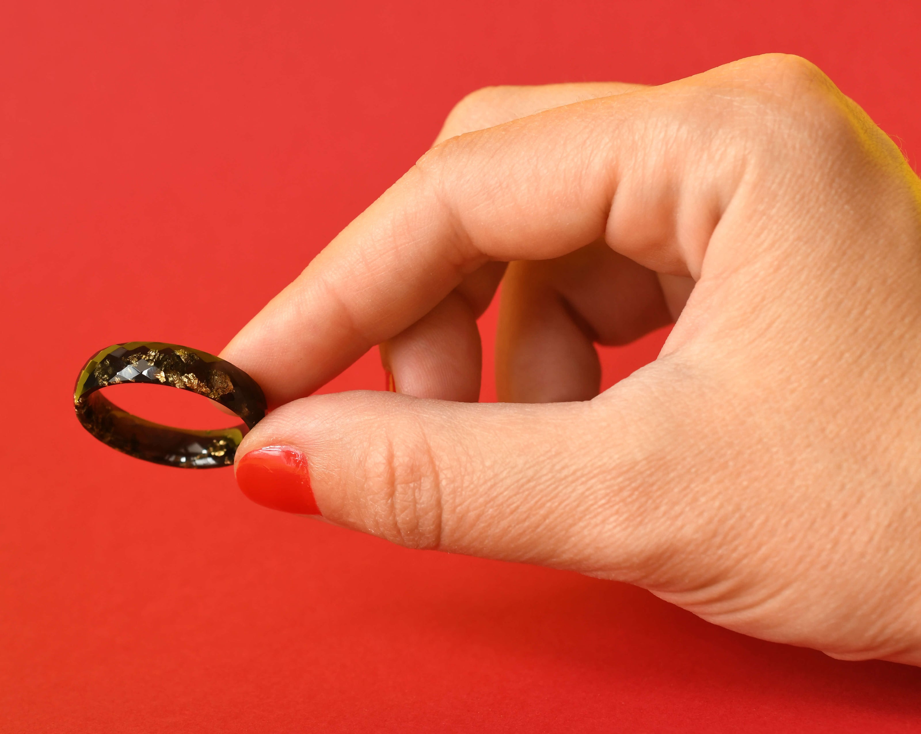 Close-up of faceted black resin ring with gold accents for men