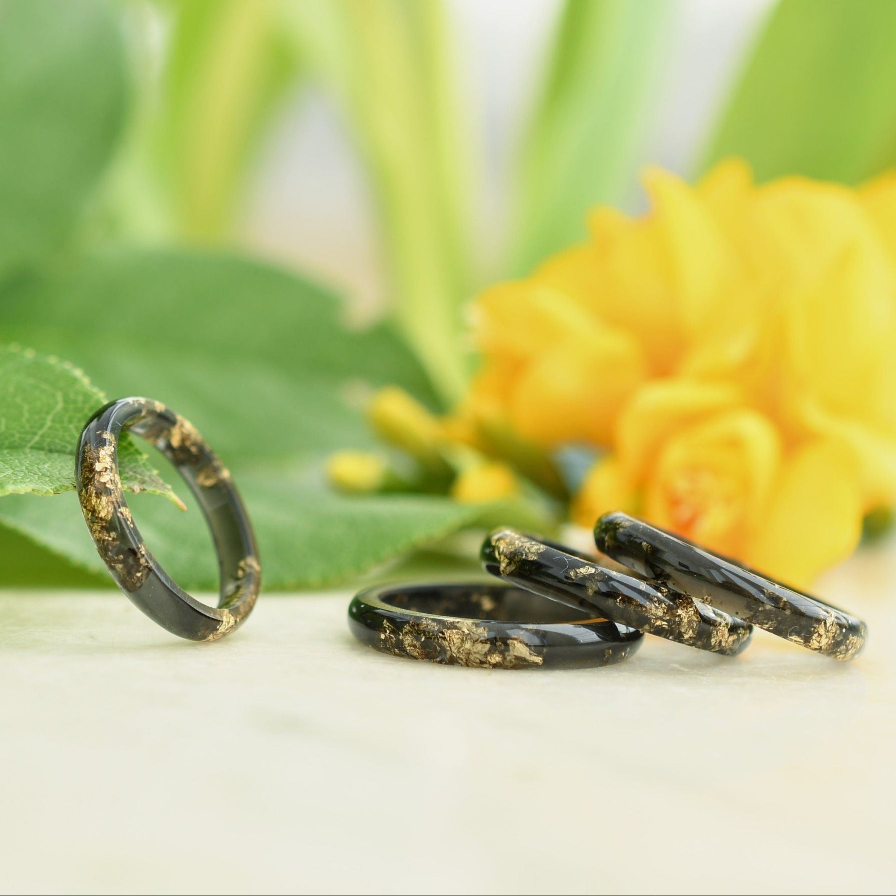 Close-up of gold flakes suspended in smooth black resin ring