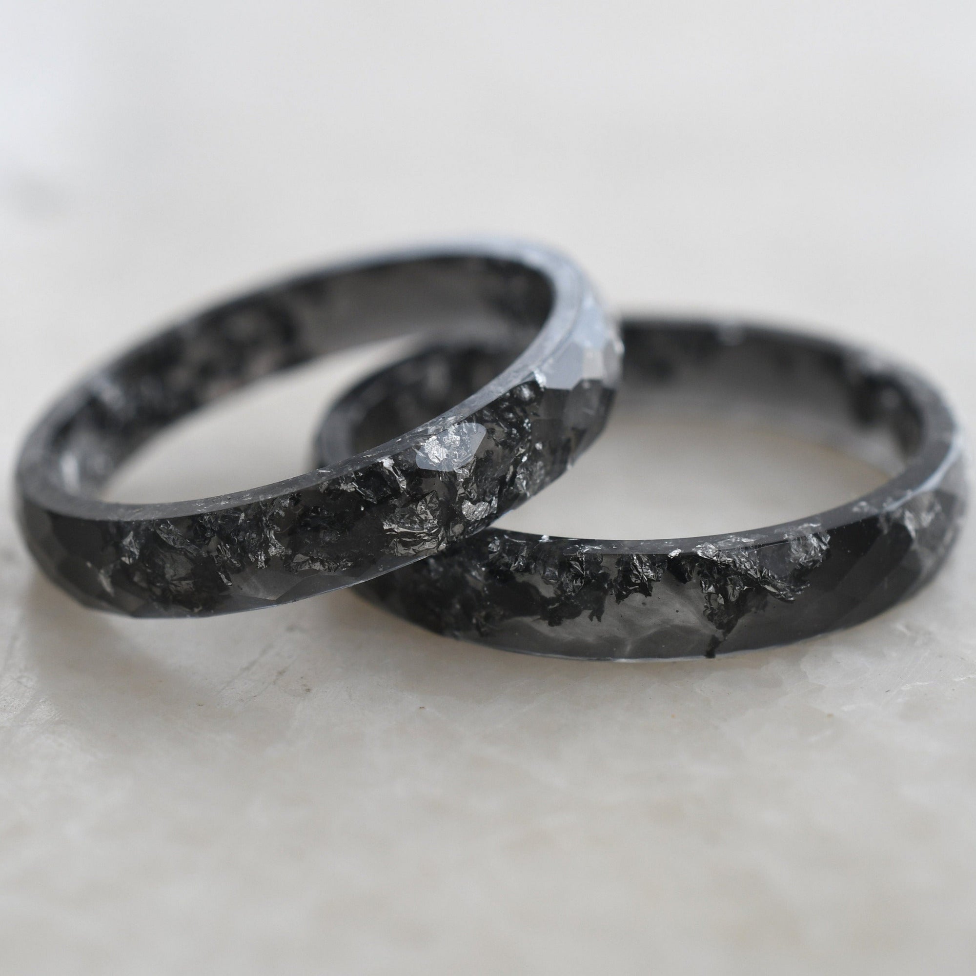 Close-up of silver flakes in black resin ring handmade by Resity
