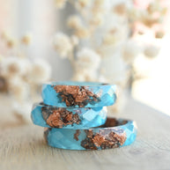 Flatlay of Blue Ember Ring showing rose gold leaf in vibrant blue matte resin