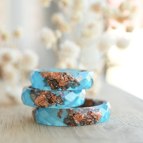 Flatlay of Blue Ember Ring showing rose gold leaf in vibrant blue matte resin