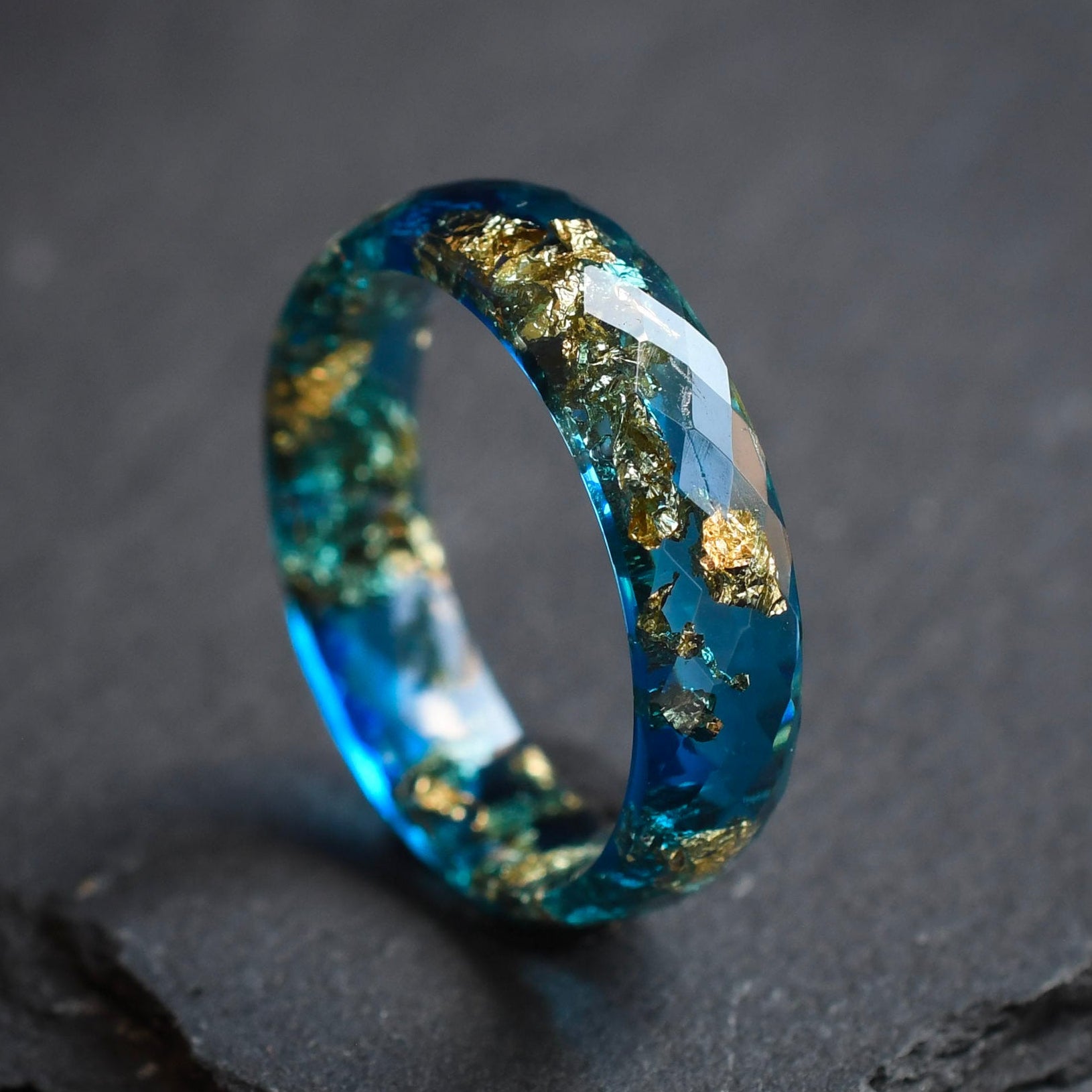 close up faceted blue resin ring with metallic gold leaf