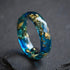 close up faceted blue resin ring with metallic gold leaf