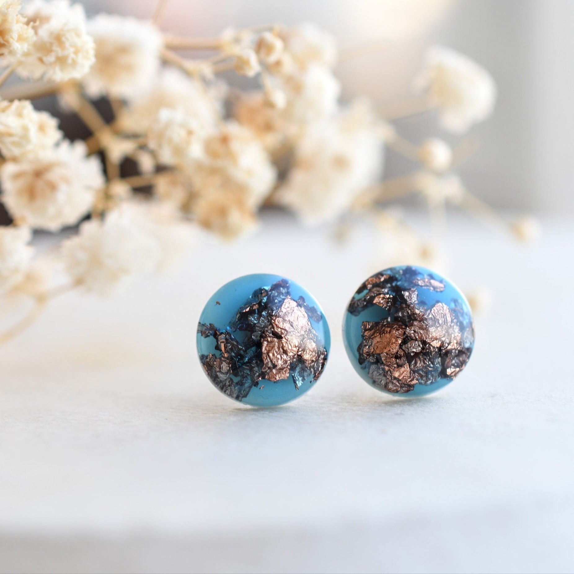 Handmade blue resin earrings with rose gold flakes displayed in gift box by Resity