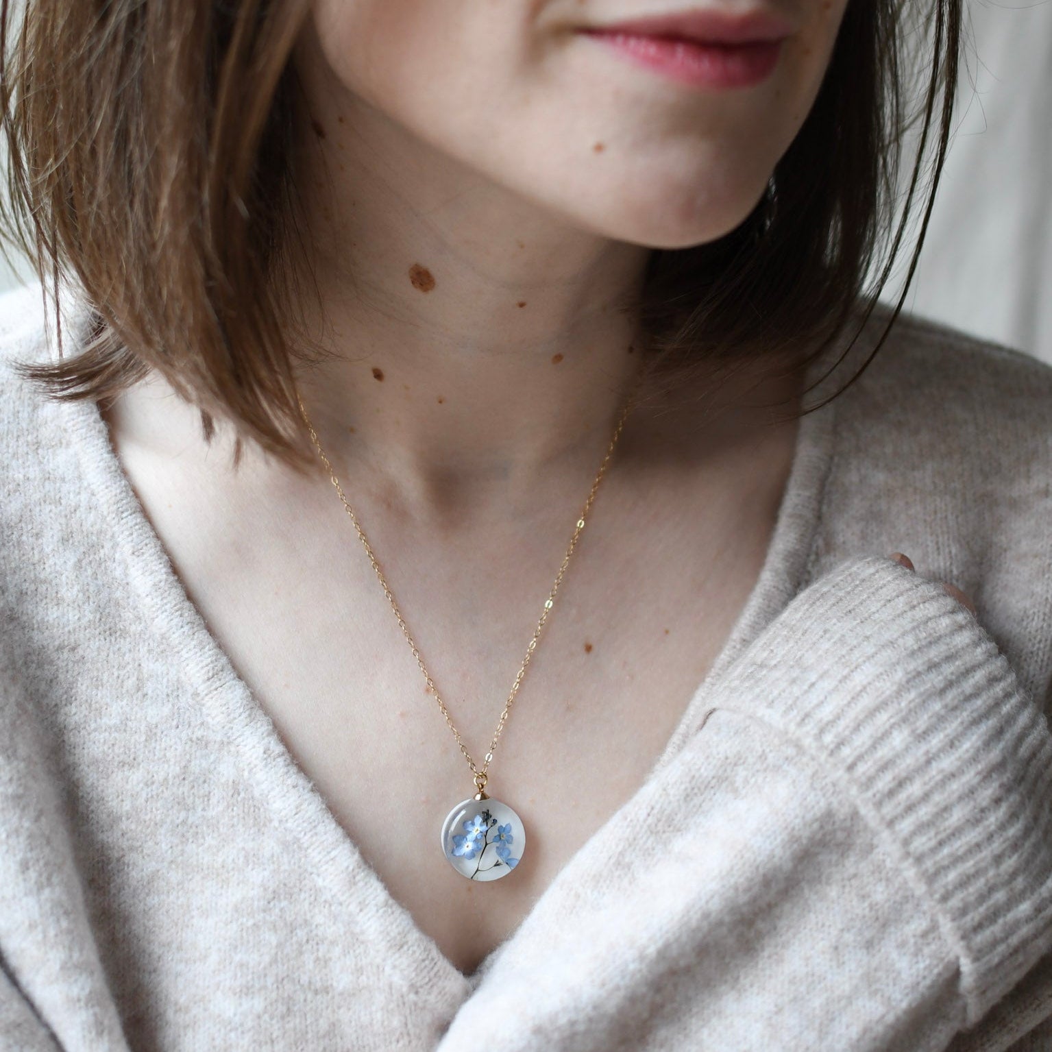 Blue Whisper Necklace — real blue flower pendant handmade in Vienna by Resity worn by model