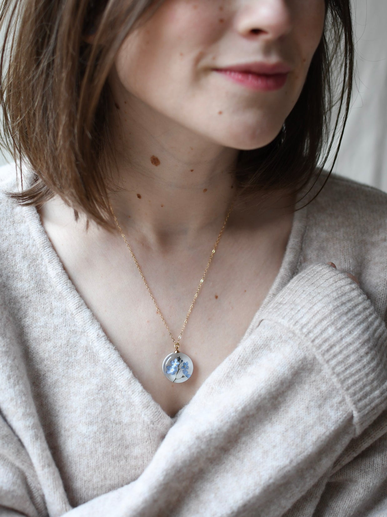 Blue Whisper Necklace — real blue flower pendant handmade in Vienna by Resity worn by model