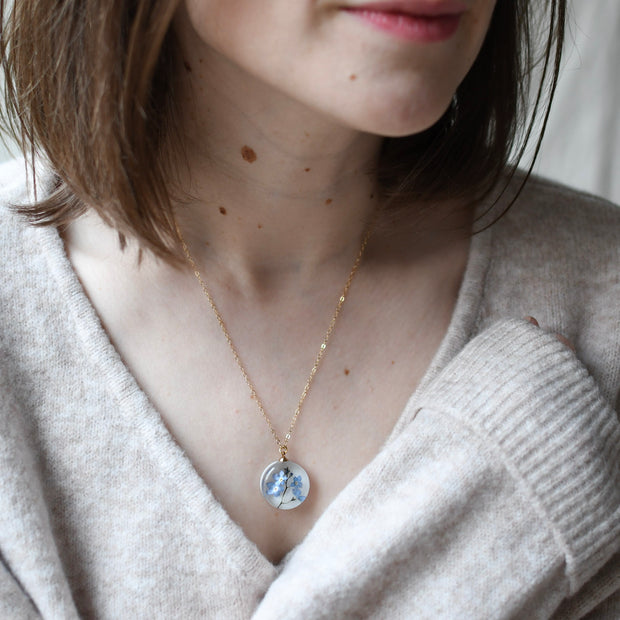 Blue Whisper Necklace — real blue flower pendant handmade in Vienna by Resity worn by model