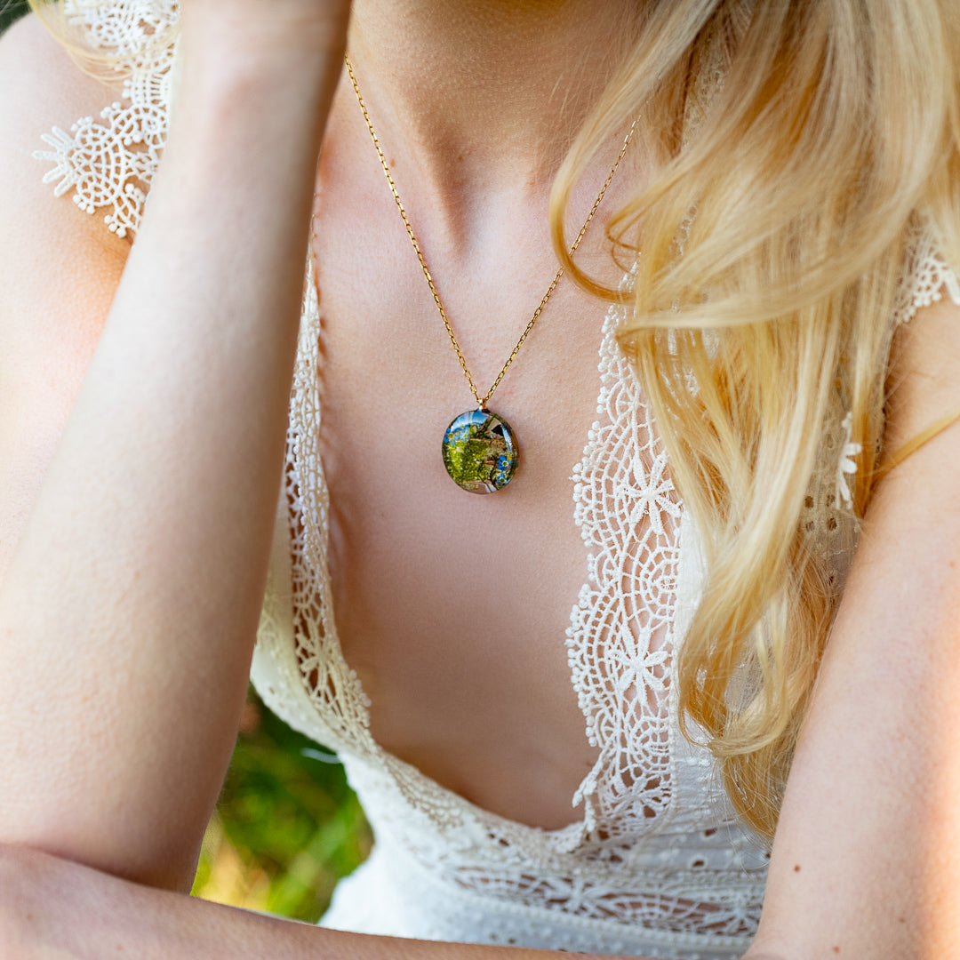 Real forget-me-nots, mushrooms, and bark preserved in resin pendant