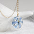 Botanical necklace featuring a vivid blue squill flower in a resin pendant