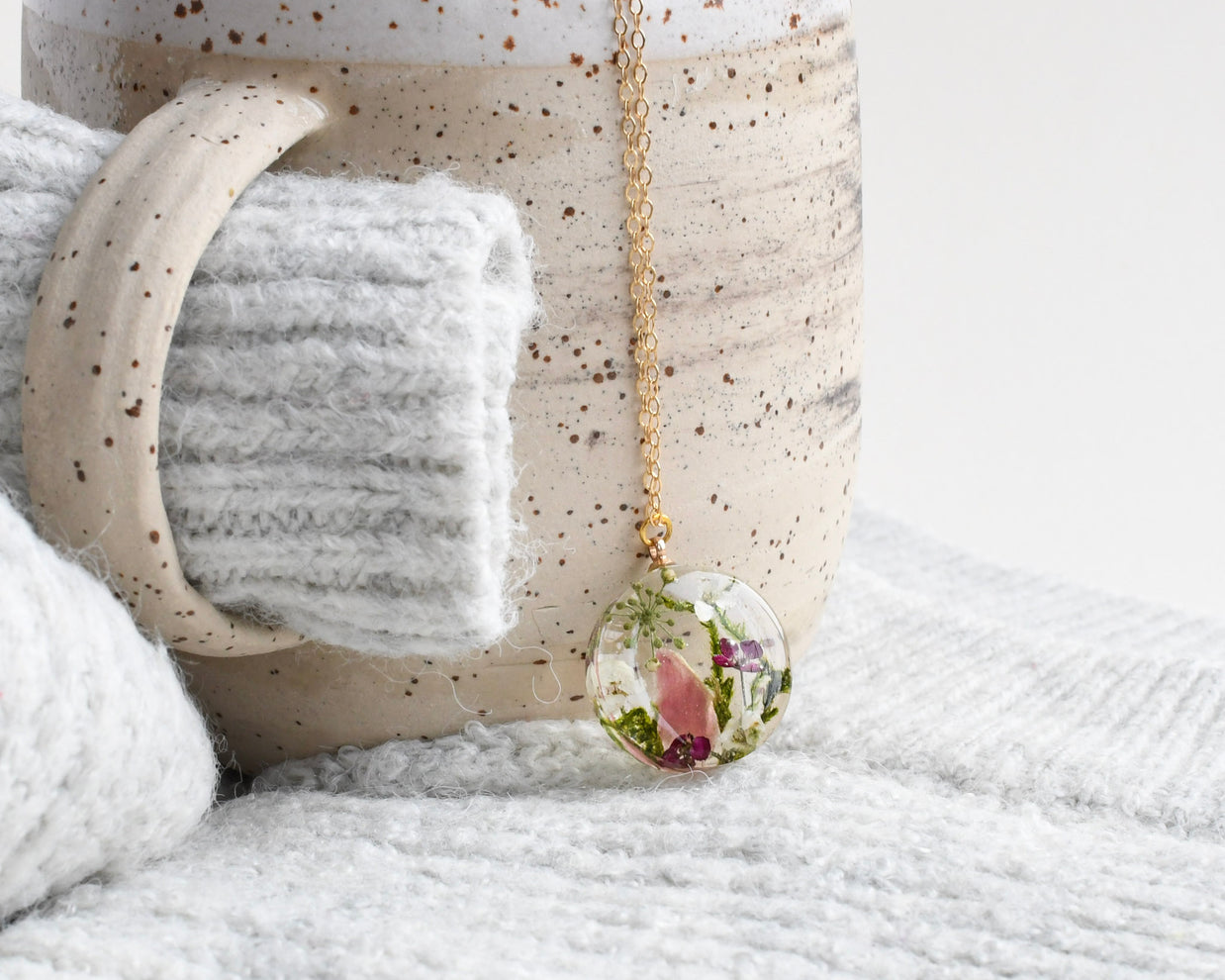Resin terrarium pendant with moss, pink alyssum, and pink tourmaline