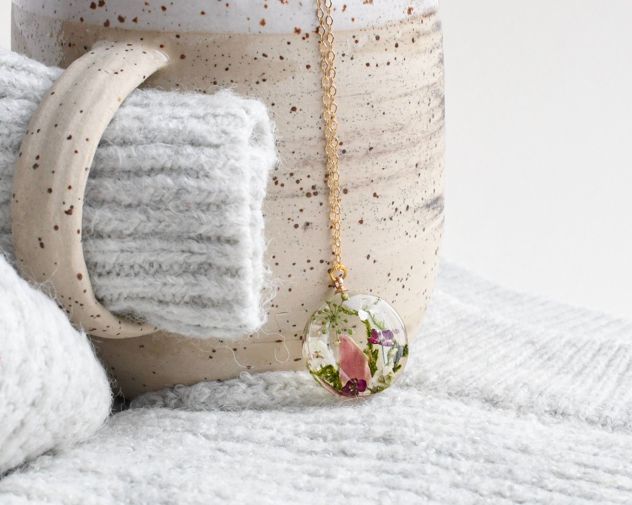 Resin terrarium pendant with moss, pink alyssum, and pink tourmaline