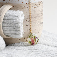 Resin terrarium pendant with moss, pink alyssum, and pink tourmaline