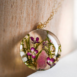 Real moss, pink flower, and tourmaline crystal encased in resin pendant
