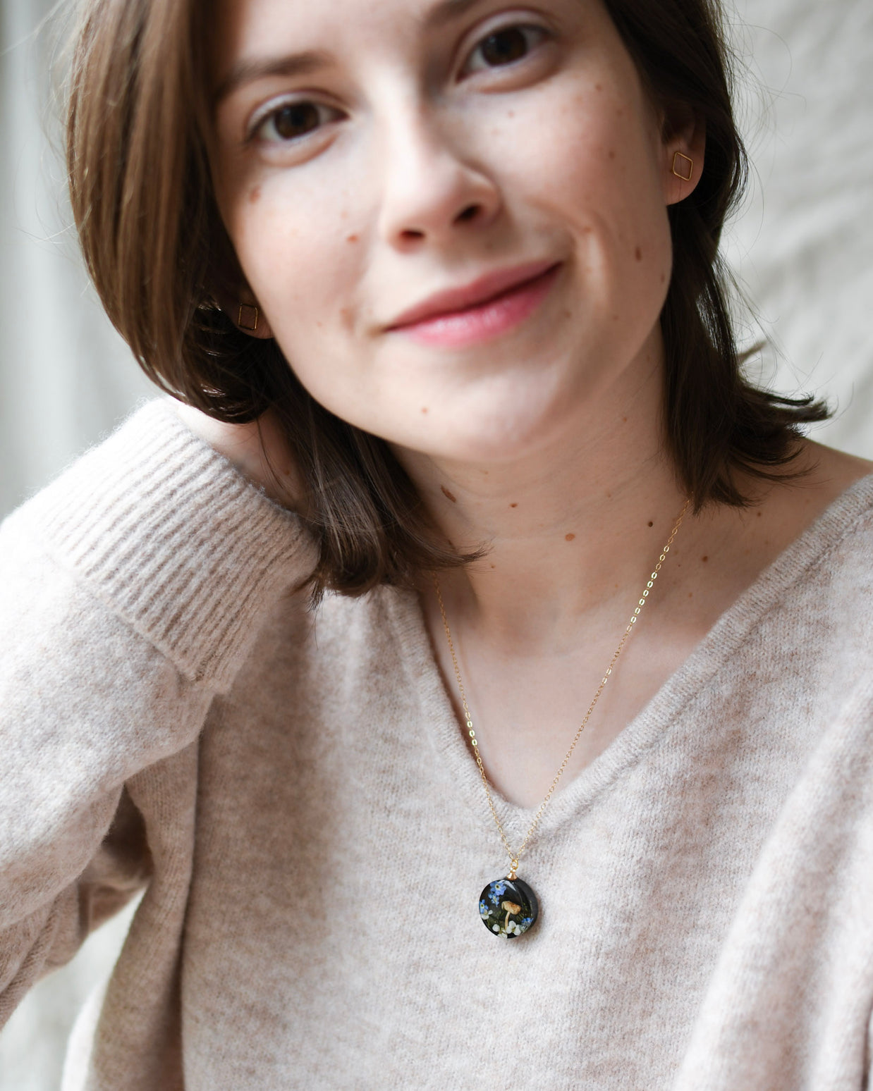 Nature-inspired handcrafted necklace worn — botanical pendant with moss, mushroom, and delicate flowers by Resity