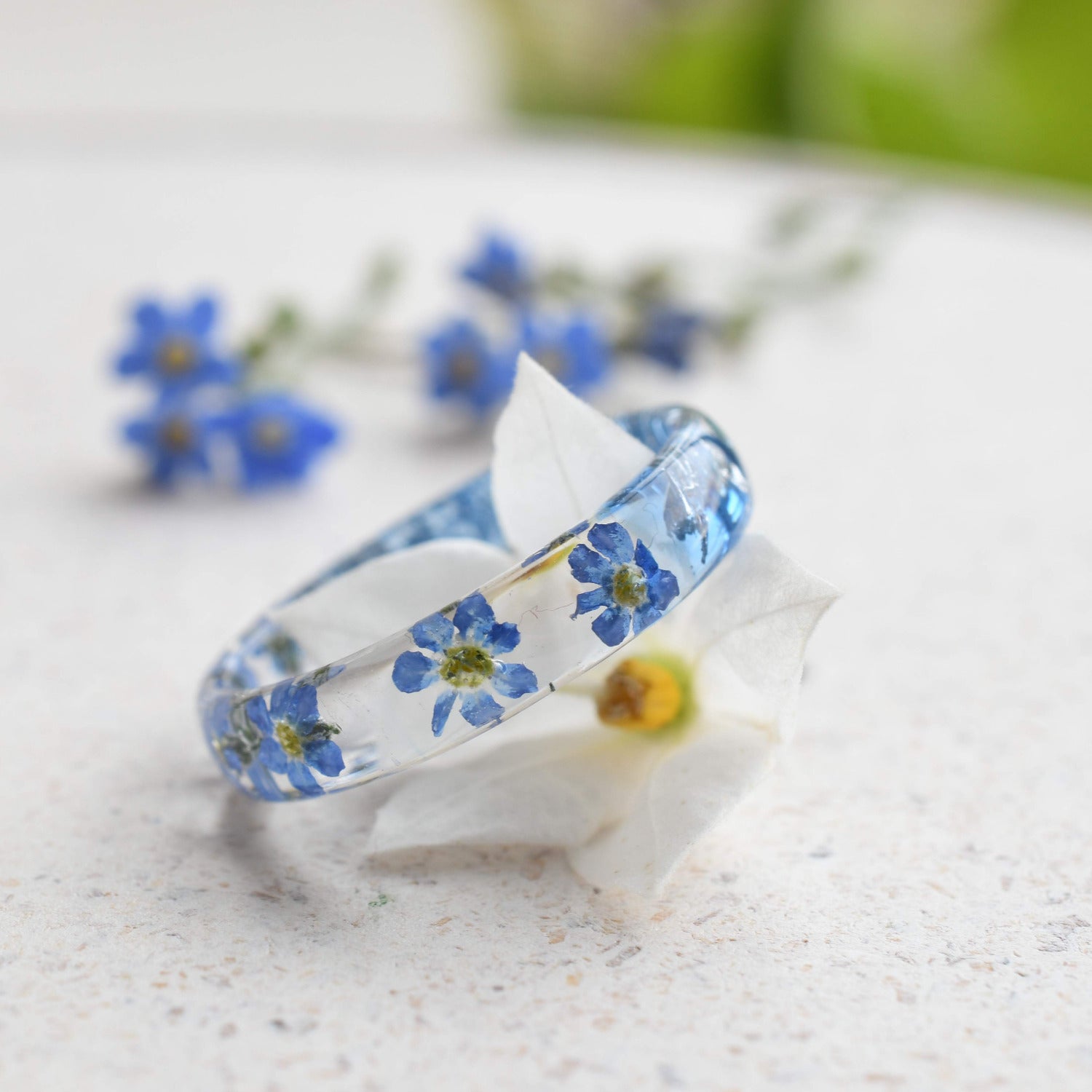 Botanical resin ring with blue forget-me-nots preserved in clear resin