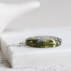 Botanical terrarium necklace with mushrooms, moss, and forget-me-nots