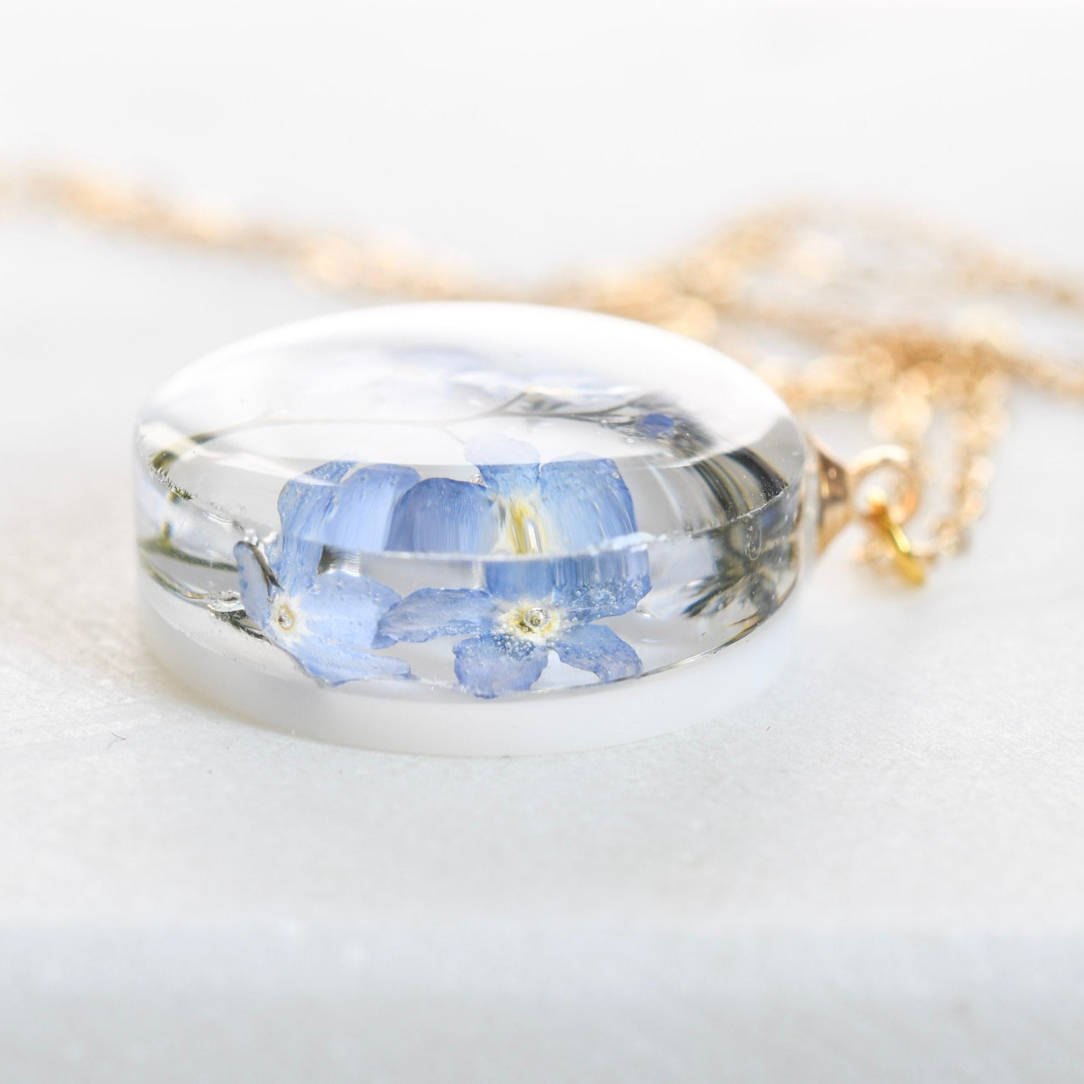 Clear resin necklace with blue flower — 20 mm round pendant crafted by European artisans