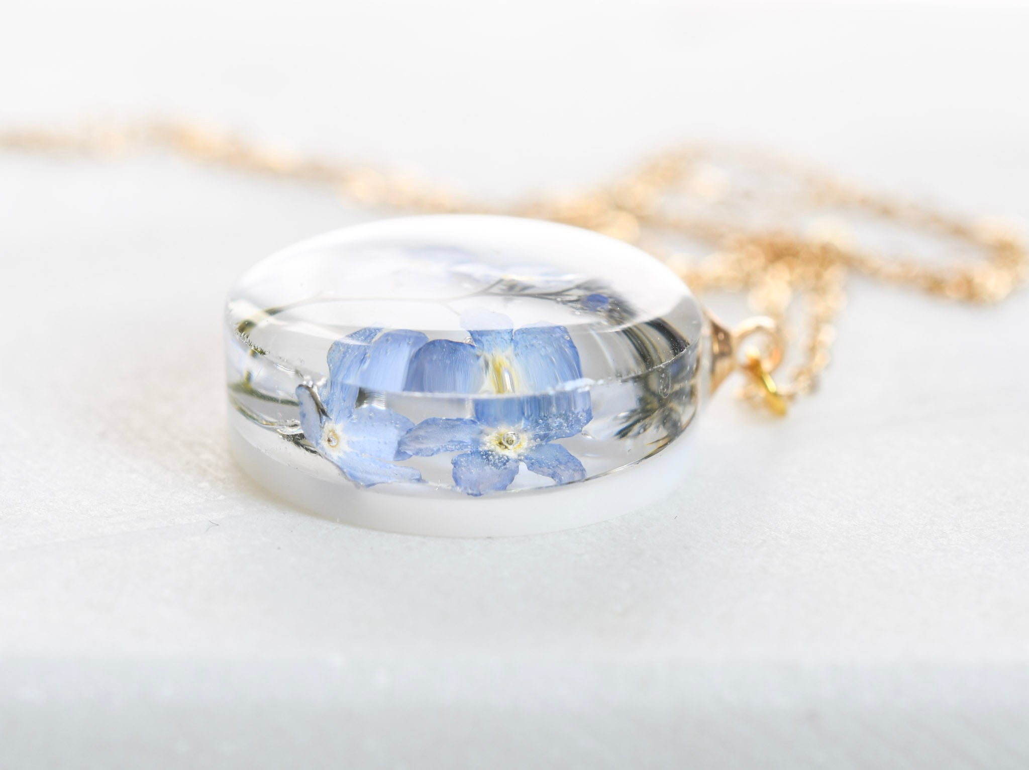 Clear resin necklace with blue flower — 20 mm round pendant crafted by European artisans