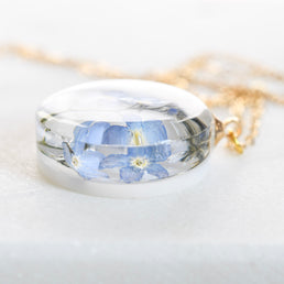 Clear resin necklace with blue flower — 20 mm round pendant crafted by European artisans