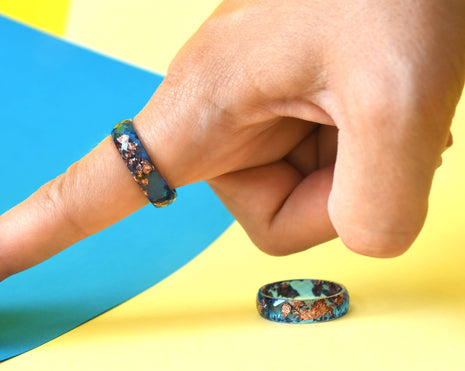 Handmade cobalt and rose gold resin ring worn on hand