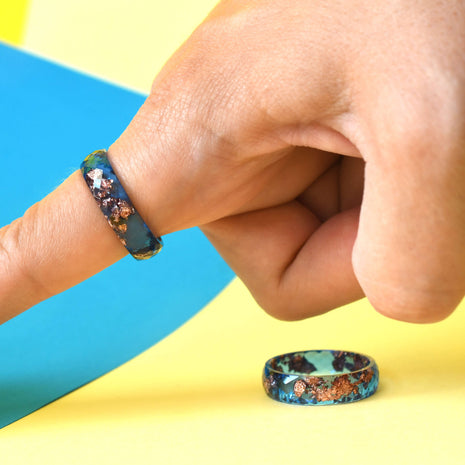 Handmade cobalt and rose gold resin ring worn on hand
