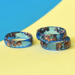 Faceted cobalt blue resin ring with rose gold leaf on white background