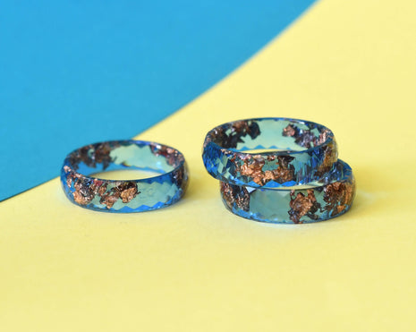 Faceted cobalt blue resin ring with rose gold leaf on white background