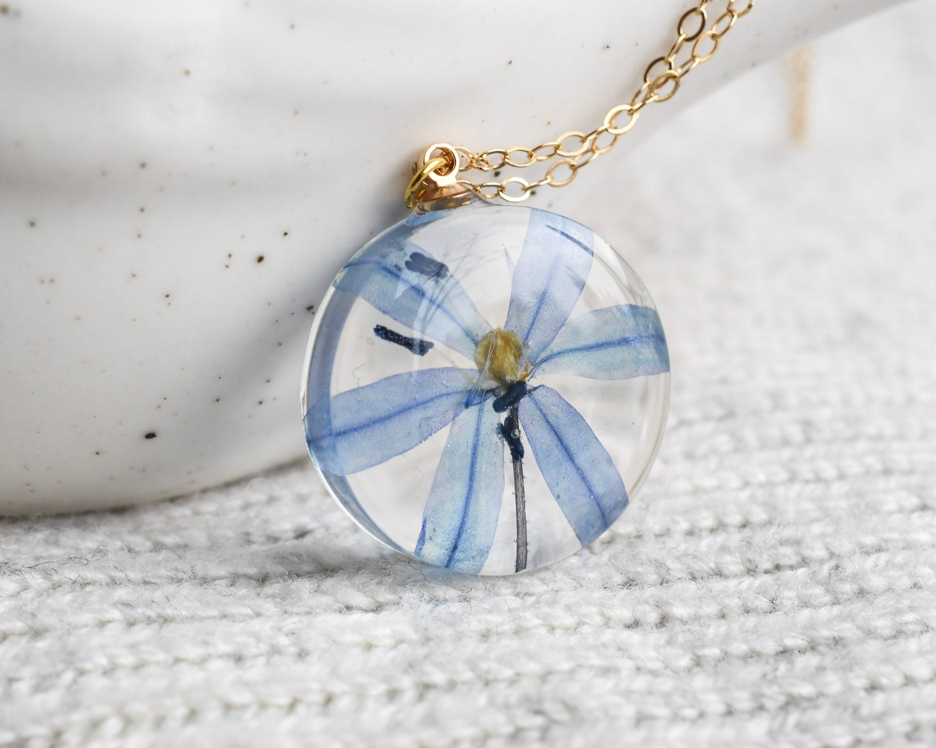 Delicate real-flower resin necklace with blue squill and fine gold chain.