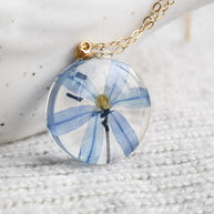 Delicate real-flower resin necklace with blue squill and fine gold chain.