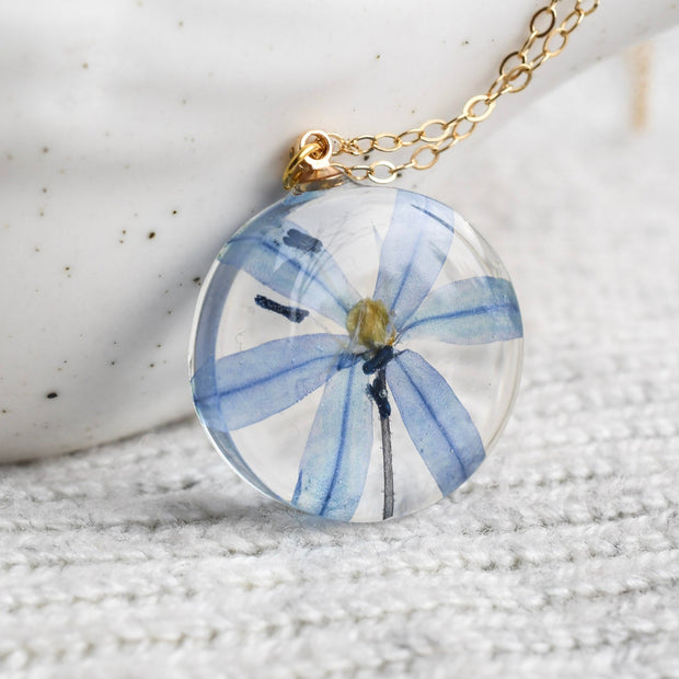 Delicate real-flower resin necklace with blue squill and fine gold chain.