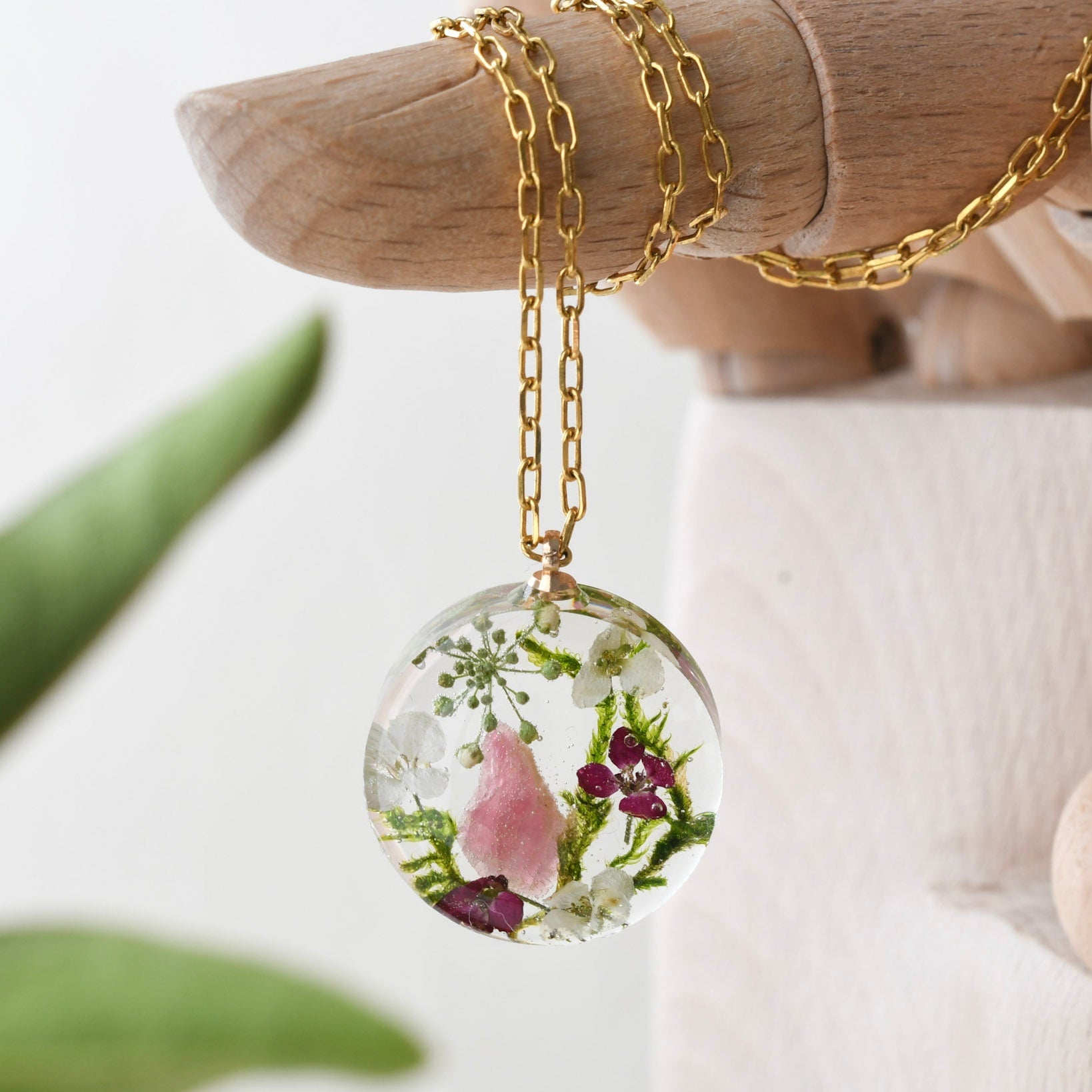 Terrarium necklace with pink tourmaline, moss, and alyssum flowers handmade by Resity in Vienna