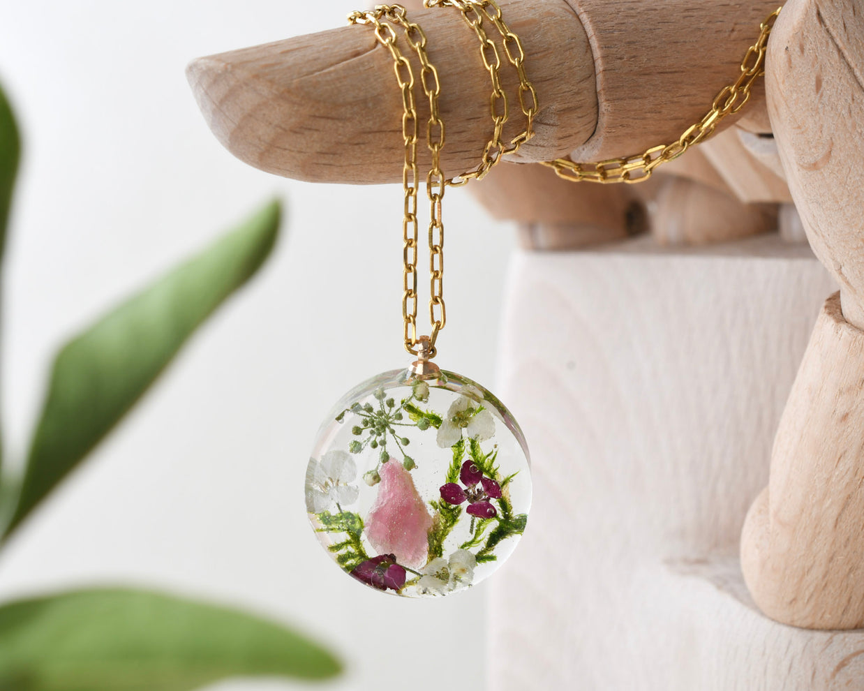 Terrarium necklace with pink tourmaline, moss, and alyssum flowers handmade by Resity in Vienna