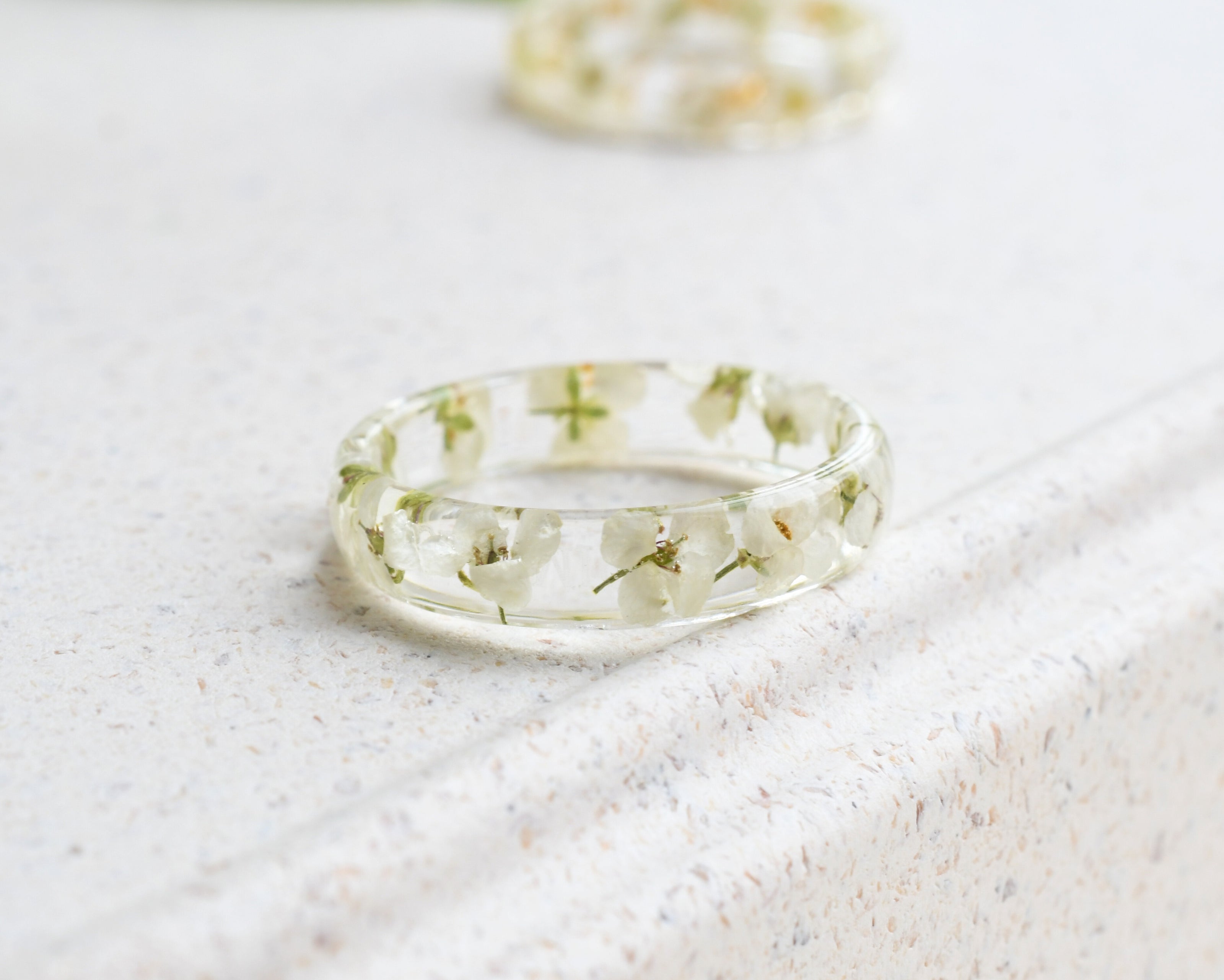 Clear resin ring with delicate white flowers inside